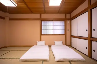 two beds in an empty room with a window at Miyabi Inn-Kameido in Tokyo