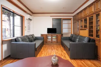 a living room with two leather couches and a tv at Miyabi Inn-Kameido in Tokyo