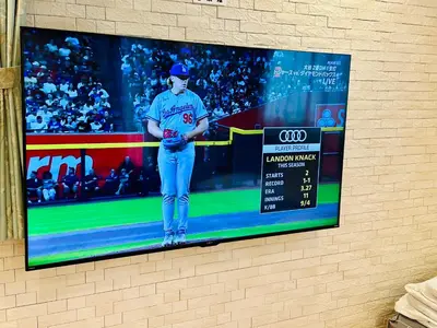 a tv screen on a wall with a baseball game at MoRi House IN西日暮里Ⅱ in Tokyo
