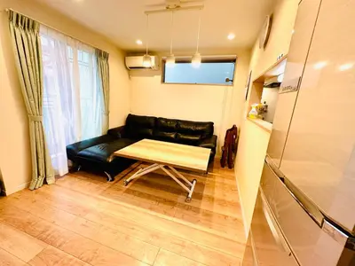 a living room with a black leather couch and a table at MoRi House IN西日暮里Ⅱ in Tokyo