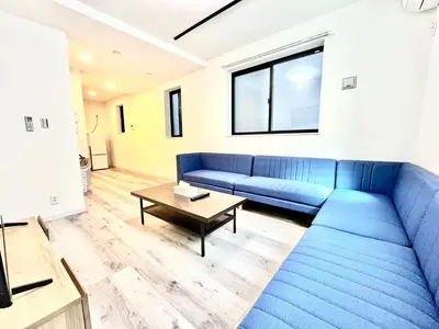 a living room with a blue couch and a table at \u5305\u68df3\u623f\u5225\u5885 \u76f4\u9054\u4e0a\u91ce2\u5206 \u53ef\u4f4f8\u4eba \u9069\u5408\u5718\u9ad4\u5bb6\u5ead\u65c5\u904a in Tokyo