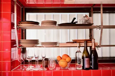 a kitchen with wine glasses and plates on a shelf at ICHINAGI Yanaka Luxury Villa near Asakusa in Tokyo