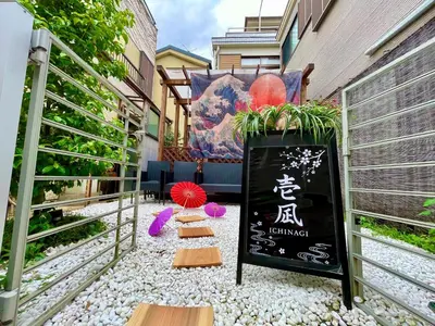 a sidewalk with a sign and some plants on it at ICHINAGI Yanaka Luxury Villa near Asakusa in Tokyo