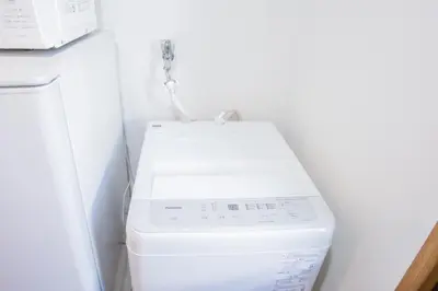 a white washer and dryer in a small bathroom at walk to Ushigome-yanagicho sta. EoWh in Tokyo