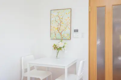 a white table with white chairs and a vase with flowers at walk to Ushigome-yanagicho sta. EoWh in Tokyo