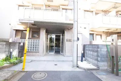 an entrance to a building with a yellow pole at walk to Ushigome-yanagicho sta. EoWh in Tokyo