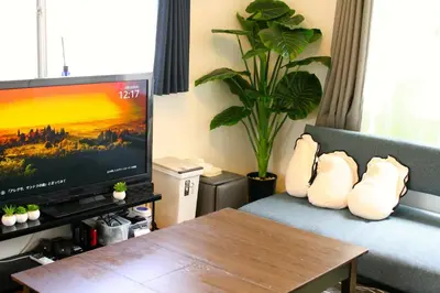 a living room with a tv and a couch with a table at \u30dc\u30fc\u30c9\u30b2\u30fc\u30e0\u304c\u697d\u3057\u3081\u308b\u65b0\u5bbf\u99c5\u5f92\u6b69\u570f\u5185\u306e\u8cb8\u5207\u30a2\u30d1\u30fc\u30c8 in Tokyo