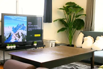 a living room with a tv and a coffee table at \u30dc\u30fc\u30c9\u30b2\u30fc\u30e0\u304c\u697d\u3057\u3081\u308b\u65b0\u5bbf\u99c5\u5f92\u6b69\u570f\u5185\u306e\u8cb8\u5207\u30a2\u30d1\u30fc\u30c8 in Tokyo