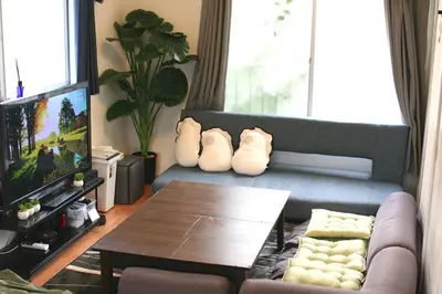 a living room with a couch and a table at \u30dc\u30fc\u30c9\u30b2\u30fc\u30e0\u304c\u697d\u3057\u3081\u308b\u65b0\u5bbf\u99c5\u5f92\u6b69\u570f\u5185\u306e\u8cb8\u5207\u30a2\u30d1\u30fc\u30c8 in Tokyo