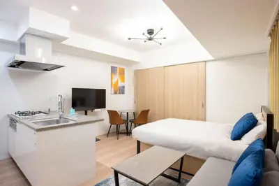 a room with a bed and a kitchen with a sink at Sun Place \u795e\u697d\u5742 in Tokyo