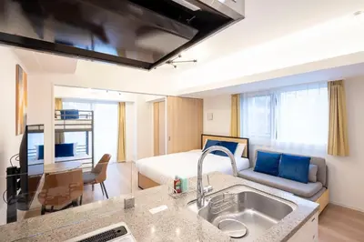 a room with a bed and a kitchen with a sink at Sun Place \u795e\u697d\u5742 in Tokyo