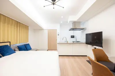 a bedroom with a large bed and a kitchen at Sun Place \u795e\u697d\u5742 in Tokyo