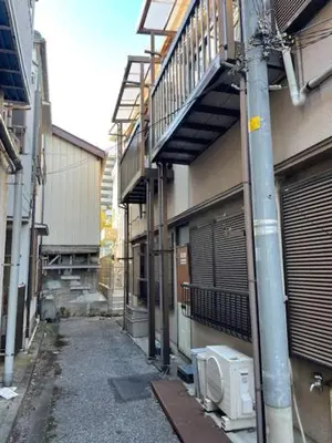 an alley with a building and a microwave on a pole at RIKASOU#101 in Tokyo