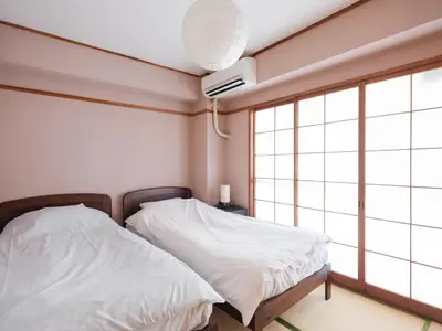 a bedroom with two white beds and a window at Grace Mukojima 701 in Tokyo