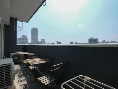 a balcony with tables and chairs and a view of the city at Grace Mukojima 701 in Tokyo