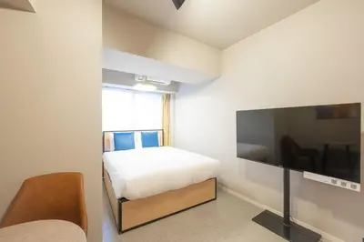 a bedroom with a bed and a flat screen tv at CREAL premier\u5927\u68ee\u5317 in Tokyo