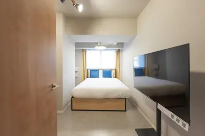 a bedroom with a bed and a flat screen tv at CREAL premier\u5927\u68ee\u5317 in Tokyo