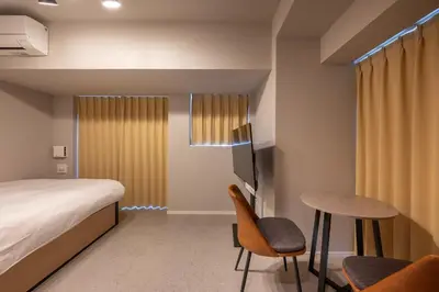 a bedroom with a bed and a table and chairs at CREAL premier\u5927\u68ee\u5317 in Tokyo