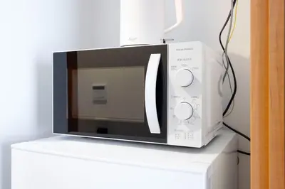 a microwave oven sitting on top of a white box at \u30d7\u30e9\u30fc\u30ba\u30bf\u30ef\u30fc\u6771\u65b0\u5bbf in Tokyo