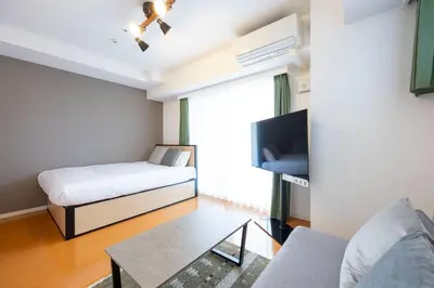 a small room with a bed and a tv at \u30d7\u30e9\u30fc\u30ba\u30bf\u30ef\u30fc\u6771\u65b0\u5bbf in Tokyo