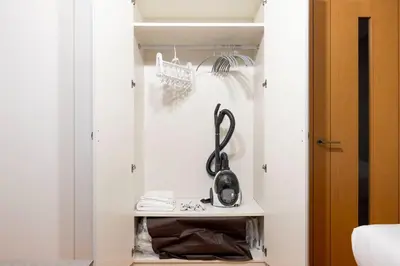 a walk in closet with a black appliance on a shelf at \u30d7\u30e9\u30fc\u30ba\u30bf\u30ef\u30fc\u6771\u65b0\u5bbf in Tokyo