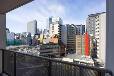 a view of a city skyline from a balcony at \u30d7\u30e9\u30fc\u30ba\u30bf\u30ef\u30fc\u6771\u65b0\u5bbf in Tokyo