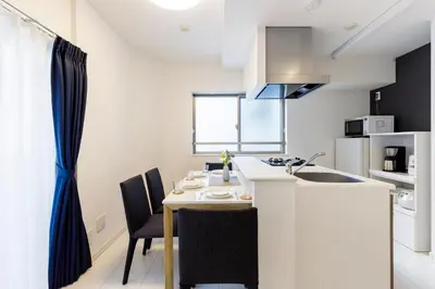 a kitchen with a table and chairs in a room at Live Casa Tokyo\u6d5c\u677e\u753a - Direct Haneda Monorail - Near Tokyo Tower - 1 Stop to Shinkansen in Tokyo