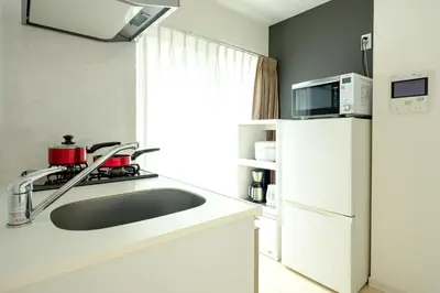 a kitchen with a sink and a microwave and a refrigerator at Live Casa Tokyo\u6d5c\u677e\u753a - Direct Haneda Monorail - Near Tokyo Tower - 1 Stop to Shinkansen in Tokyo