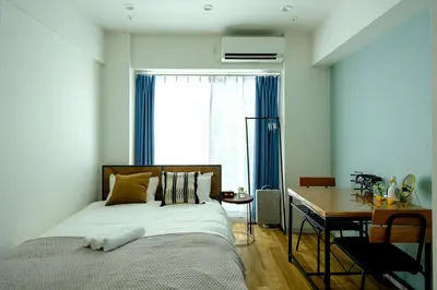 a bedroom with a bed and a desk and a window at Shinbashi Residence - Near Ginza & Food Scene - Direct HND,NRT 東京新橋579 in Tokyo