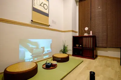 a room with two ottomans and a stage with a presentation at Shinbashi Residence - Near Ginza & Food Scene - Direct HND,NRT 東京新橋579 in Tokyo