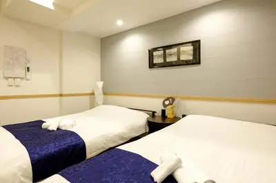 a room with two beds and a table at Shinbashi Residence - Near Ginza & Food Scene - Direct HND,NRT 東京新橋579 in Tokyo