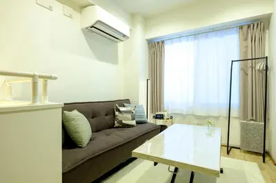 a living room with a couch and a table at Shinbashi Residence - Near Ginza & Food Scene - Direct HND,NRT 東京新橋579 in Tokyo
