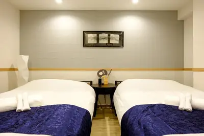 a room with two beds and a table at Shinbashi Residence - Near Ginza & Food Scene - Direct HND,NRT 東京新橋579 in Tokyo