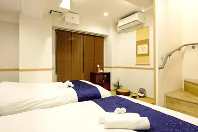 two beds in a hotel room with a window at Shinbashi Residence - Near Ginza & Food Scene - Direct HND,NRT 東京新橋579 in Tokyo