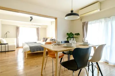 a living room with a table and chairs and a bed at Modern Meguro Apt - 2 Mins Walk - Direct to Shibuya,Ebisu,Haneda - \u9577\u8005\u4e38\u30d3\u30eb in Tokyo