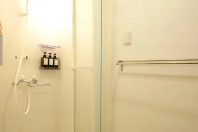a bathroom with a shower and a white door at Modern Meguro Apt - 2 Mins Walk - Direct to Shibuya,Ebisu,Haneda - \u9577\u8005\u4e38\u30d3\u30eb in Tokyo