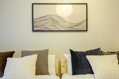 a living room with a couch and a picture on the wall at Modern Meguro Apt - 2 Mins Walk - Direct to Shibuya,Ebisu,Haneda - \u9577\u8005\u4e38\u30d3\u30eb in Tokyo