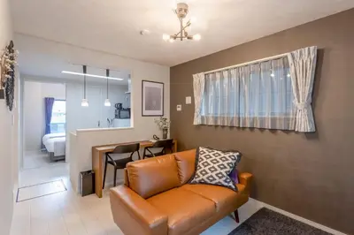 a living room with a leather couch and a dining room at Bijou Suites Cocoa in Tokyo