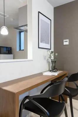 a dining room with a wooden table and two chairs at Bijou Suites Cocoa in Tokyo