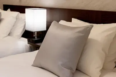 a white pillow sitting on a bed with a lamp at Bijou Suites Cocoa in Tokyo