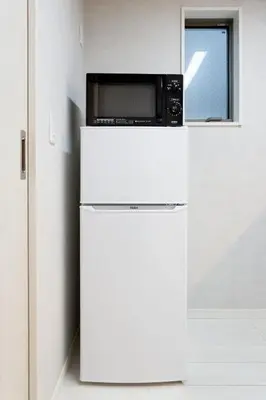 a microwave sitting on top of a white refrigerator at Bijou Suites Cocoa in Tokyo