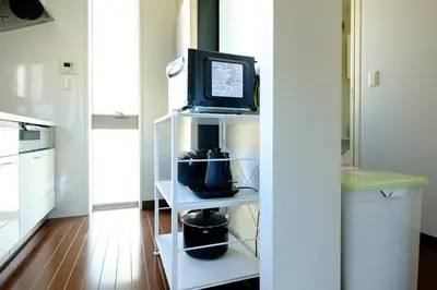 a microwave sitting on a shelf in a kitchen at Nishi-Shinjuku Residence - 2F House - Quiet Area Walkable to Shinjuku Station - Ciel\u897f\u65b0\u5bbf in Tokyo