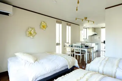 a bedroom with two beds and a dining room at Nishi-Shinjuku Residence - 2F House - Quiet Area Walkable to Shinjuku Station - Ciel\u897f\u65b0\u5bbf in Tokyo