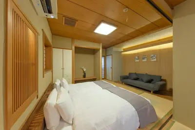 a large white bed in a room with a couch at Shinjuku Zen House 1F 70sqm Spacious Townhouse No Stairs R1 in Tokyo
