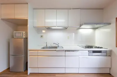 a white kitchen with a sink and a refrigerator at Shinjuku Zen House 1F 70sqm Spacious Townhouse No Stairs R1 in Tokyo