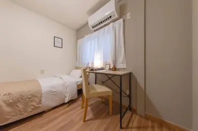 a bedroom with a bed and a desk with a chair at Shinjuku Zen House 1F 70sqm Spacious Townhouse No Stairs R1 in Tokyo