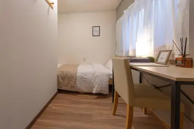 a bedroom with a bed and a desk with a laptop at Shinjuku Zen House 1F 70sqm Spacious Townhouse No Stairs R1 in Tokyo