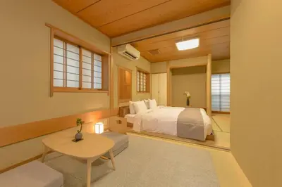 a bedroom with a bed and a table and windows at Shinjuku Zen House 1F 70sqm Spacious Townhouse No Stairs R1 in Tokyo