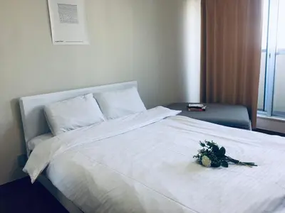 a white bed with a bouquet of flowers on it at \u85e4\u548c\u30a8\u30af\u30b7\u30fc\u30eb\u9053\u7384\u5742 - \u6e0b\u8c37\u99c5\u304b\u3089\u5f92\u6b694\u5206 \u9577\u671f\u6ede\u5728\u306b\u975e\u5e38\u306b\u4fbf\u5229\u3067\u3059 in Tokyo