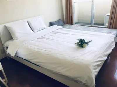 a white bed with a bouquet of flowers on it at \u85e4\u548c\u30a8\u30af\u30b7\u30fc\u30eb\u9053\u7384\u5742 - \u6e0b\u8c37\u99c5\u304b\u3089\u5f92\u6b694\u5206 \u9577\u671f\u6ede\u5728\u306b\u975e\u5e38\u306b\u4fbf\u5229\u3067\u3059 in Tokyo